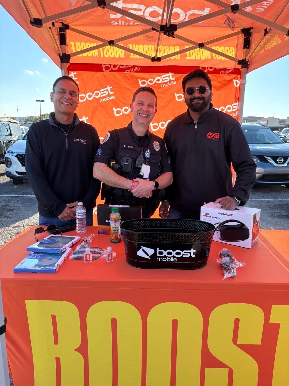 The RBFC team with a local police officer at a Boost Mobile community event